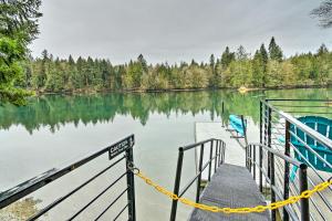 a dock on a lake with trees in the background at Dreamy Bayfront Cabin with View, Dock and Kayaks in Olympia