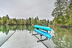a dock with blue boats on the water at Dreamy Bayfront Cabin with View, Dock and Kayaks in Olympia