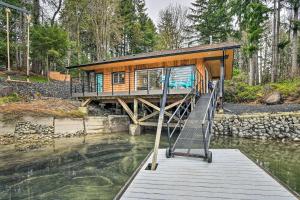 a house on a bridge over a body of water at Dreamy Bayfront Cabin with View, Dock and Kayaks in Olympia