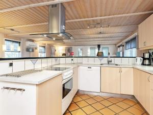 cocina con electrodomésticos blancos y techo de madera en 14 person holiday home in Vejers Strand, en Vejers Strand
