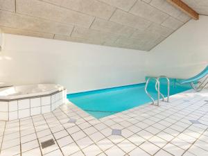 a bathroom with a swimming pool and a tub at 14 person holiday home in Vejers Strand in Vejers Strand