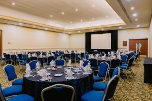 a conference room with tables and chairs and a screen at Holiday Inn Merida by IHG in Mérida +87 photos