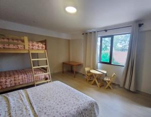 a bedroom with a bunk bed and a desk and a window at Como en Casa Torotoro in Torotoro