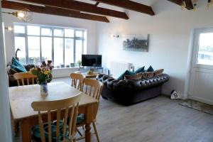 a living room with a table and a couch at Luxury, Modern Barn Conversion in Thursford