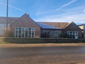 a red brick house with windows and a street at Luxury, Modern Barn Conversion in Thursford