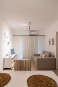 a white living room with a couch and a desk at Departamento Laura con Cochera in Villa María