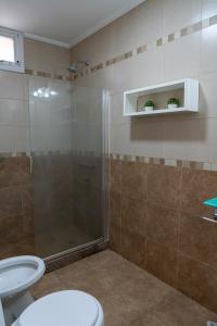 a bathroom with a shower and a toilet and a sink at Departamento Laura con Cochera in Villa María +14 photos