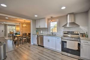 a large kitchen with white cabinets and a dining room at Modern Commerce House Rental with Fire Pit! in Commerce