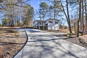 a driveway leading to a house in the woods at Modern Commerce House Rental with Fire Pit! in Commerce