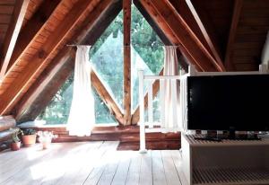 a living room with a large window and a tv at Cabaña La pionera in San Carlos de Bariloche