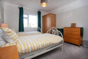 - une chambre avec un lit, une commode et une fenêtre dans l'établissement Seymour House, à Exmouth