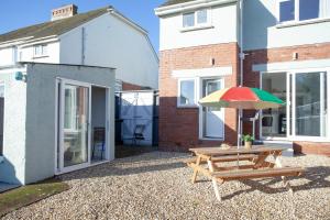 a patio with a picnic table and an umbrella at Seymour House in Exmouth