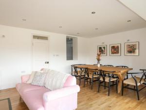 sala de estar con sofá rosa y mesa en Ynys Faelog Cottage en Menai Bridge