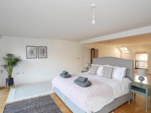 1 dormitorio con 1 cama blanca grande y 1 alfombra en Ynys Faelog Cottage en Menai Bridge