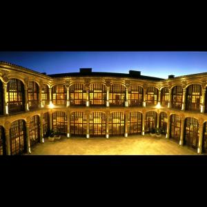 un gran edificio con muchas ventanas por la noche en Parador de Zamora, en Zamora