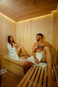 un hombre y una mujer sentados en una sauna en Orei Private Suites "Adult Only", en Trujillo