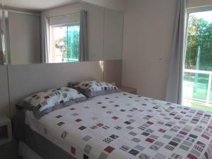 1 dormitorio con 1 cama con edredón en Casa com spa- cod 113, en Bombinhas