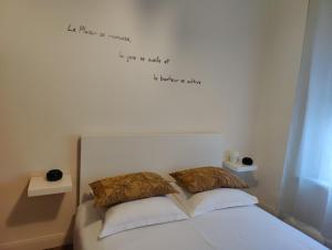 a bedroom with a bed with words on the wall at L'appart du Canal in Carcassonne
