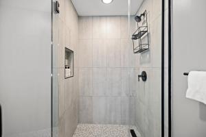 a bathroom with a shower with a glass door at Coda on Half, a Placemakr Experience in Washington