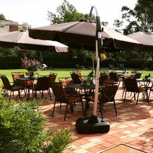 a patio with tables and chairs with an umbrella at GRAND HOTEL SERGIJO RESIDENCE superior Adult only luxury boutique hotel in Piešťany