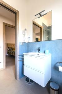 a bathroom with a white sink and a mirror at Hostly - Cisanello Suite Apartment - Light and Colors in Pisa