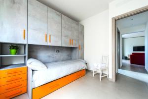 1 dormitorio con 1 cama con cajones y armarios de color naranja en Hostly - Cisanello Suite Apartment - Light and Colors en Pisa