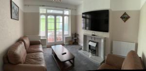 sala de estar con sofá y chimenea en Amazing and Romantic O2 Arena 4 Bedrooms House free parking en Londres