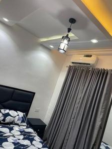 - une chambre avec un lit et un plafond avec un ventilateur dans l'établissement GS HOMES, à Lagos