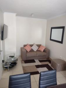 a living room with a couch and a table at Departamento a pasos de la playa y centros comerciales in La Serena