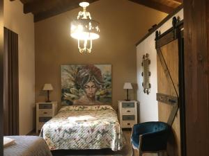 a bedroom with a bed with a painting on the wall at Las Villas de Fuentidueña in Fuentidueña +275 photos
