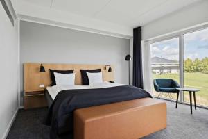 a bedroom with a bed and a large window at Best Western Plus Hotel Fredericia in Fredericia