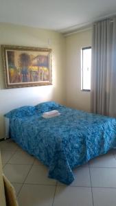 sypialnia z łóżkiem z niebieskim kocem i oknem w obiekcie Pousada Central w mieście São Benedito