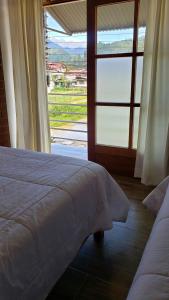 - une chambre avec un lit et une grande fenêtre dans l'établissement Las Yungas Hospedaje, à Oxapampa
