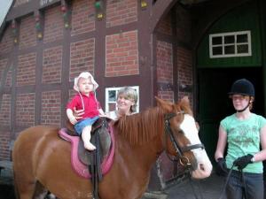 Eine Frau und ein Kind, die auf einem Pferd sitzen in der Unterkunft Reiterhof Könning in Freren