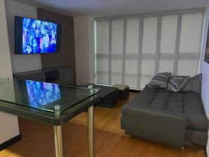 sala de estar con sofá y mesa de cristal en Apartamento en Medellín, laureles, en Medellín
