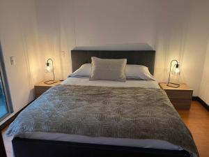 1 dormitorio con 1 cama grande y 2 lámparas en Apartamento en Medellín, laureles, en Medellín