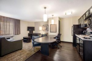 a living room with a table and chairs in a hotel room at Sonesta Simply Suites Dallas Las Colinas in Irving