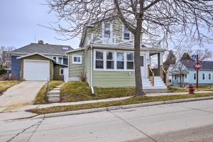 a green house with a stop sign on a street at Family-Friendly House Walk to Lake Michigan! in Sheboygan