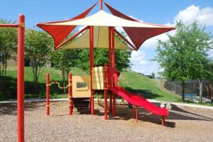 a playground with a slide and an umbrella at Hidden gem! Gorgeous villa next to Disney in Kissimmee