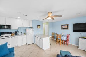 uma cozinha com armários brancos e uma parede azul em The American Dream em Gulf Shores