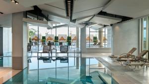 a lobby with a pool and chairs and glass floors at Crowne Plaza Florya Istanbul by IHG in Istanbul