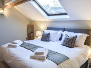 a bedroom with a bed with towels on it at The Barn in Spofforth