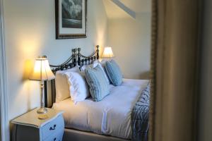 a bedroom with a bed with blue and white pillows at The Black Swan in Ravenstonedale