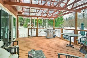 - une terrasse couverte avec un barbecue et une table dans l'établissement Secluded Riverfront Cabin Rental in Easton!, à Pine Glen