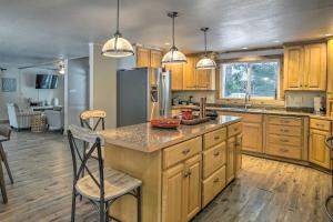 una cocina con armarios de madera y una isla de cocina con sillas en Secluded Riverfront Cabin Rental in Easton!, en Pine Glen