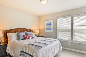 a bedroom with a bed and two windows at Ocean Shores House with Hot Tub - Walk to Beach in Ocean Shores