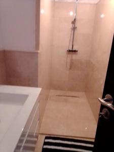 een witte badkamer met een bad en een douche bij Résidence les jardins d'assilah in Asilah