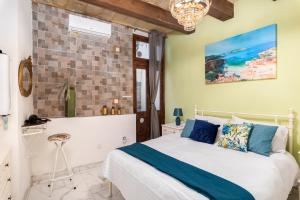 ein Schlafzimmer mit einem weißen Bett mit blauen Kissen in der Unterkunft Chic, Stylish 1 Bedroom Maisonette - Close to Valletta in Floriana