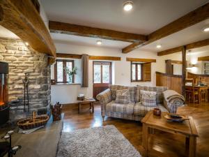 a living room with a couch and a stone fireplace at Grayrigg Foot Stable in Grayrigg