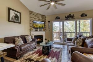 sala de estar con muebles de cuero y chimenea en High In The Smokies, en Gatlinburg